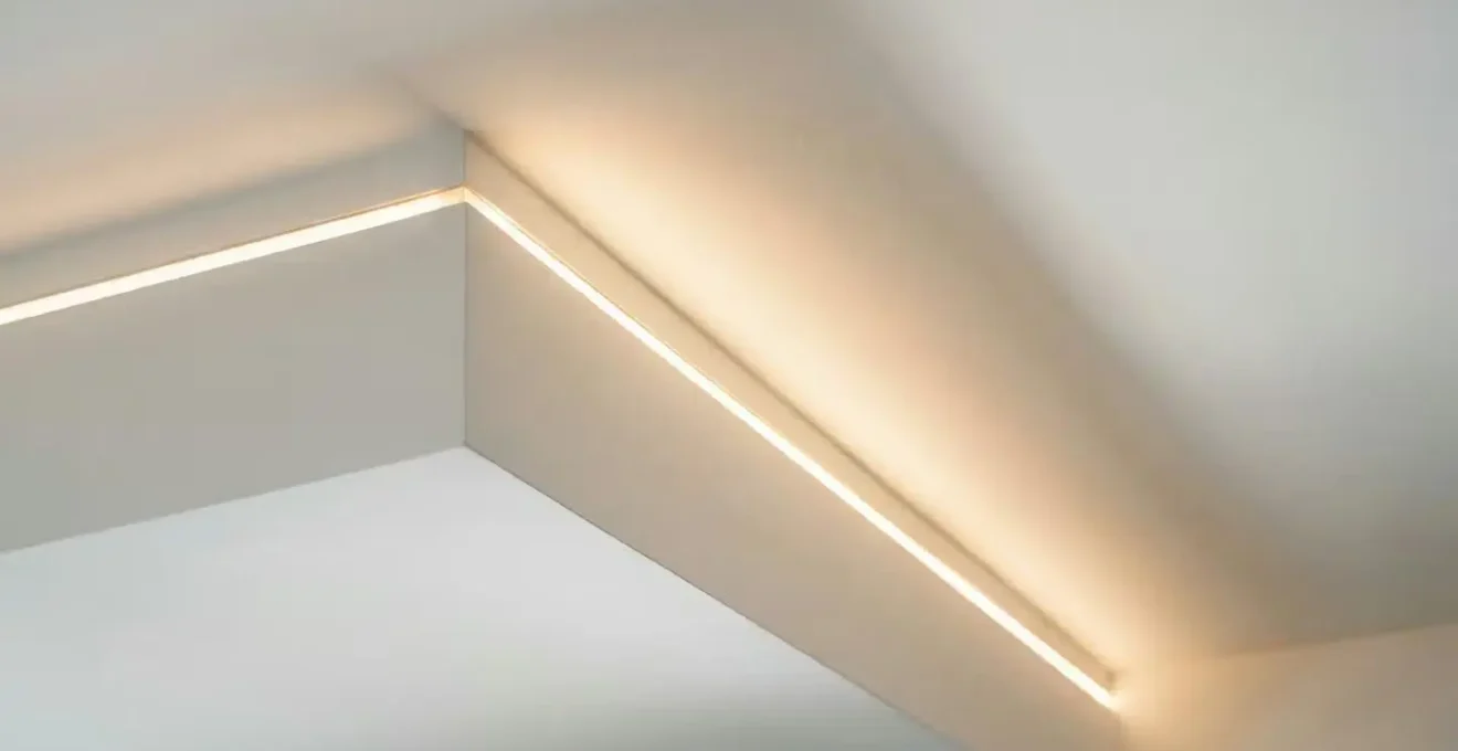 Architectural detail showing shadow gap LED lighting creating elegant transition between ceiling bulkhead and main ceiling plane