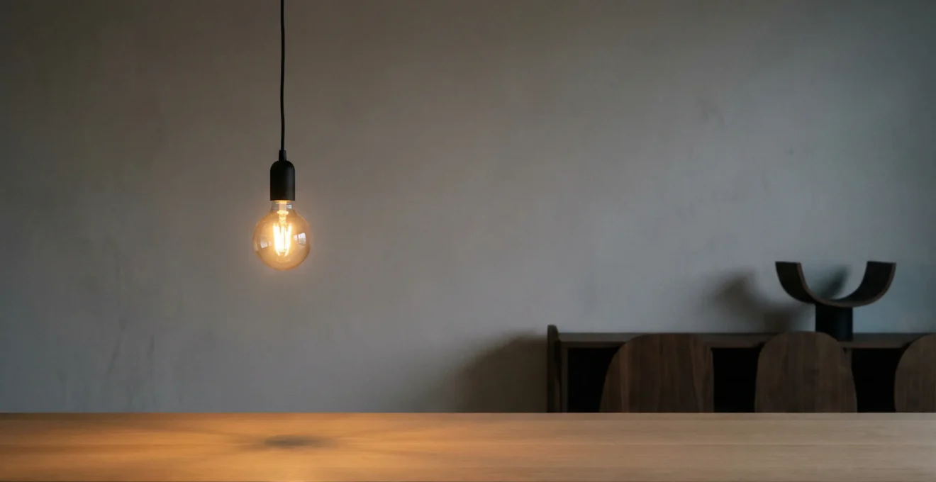 A dimmable LED bulb glowing softly at low brightness in a modern living room setting with warm ambient lighting