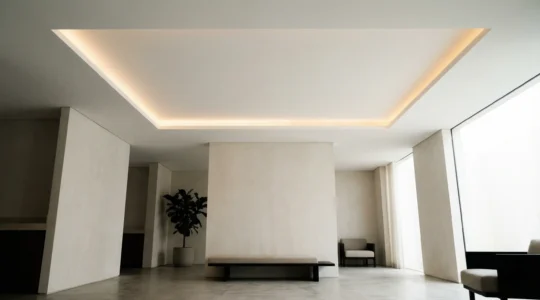 Modern minimalist white ceiling with subtle shadow gap LED lighting creating an elegant ambient glow around the perimeter
