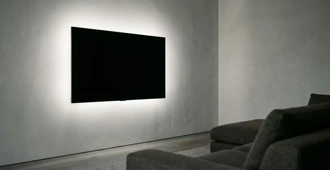 Soft LED backlight glow emanating from behind a wall-mounted television in a dimly lit living room